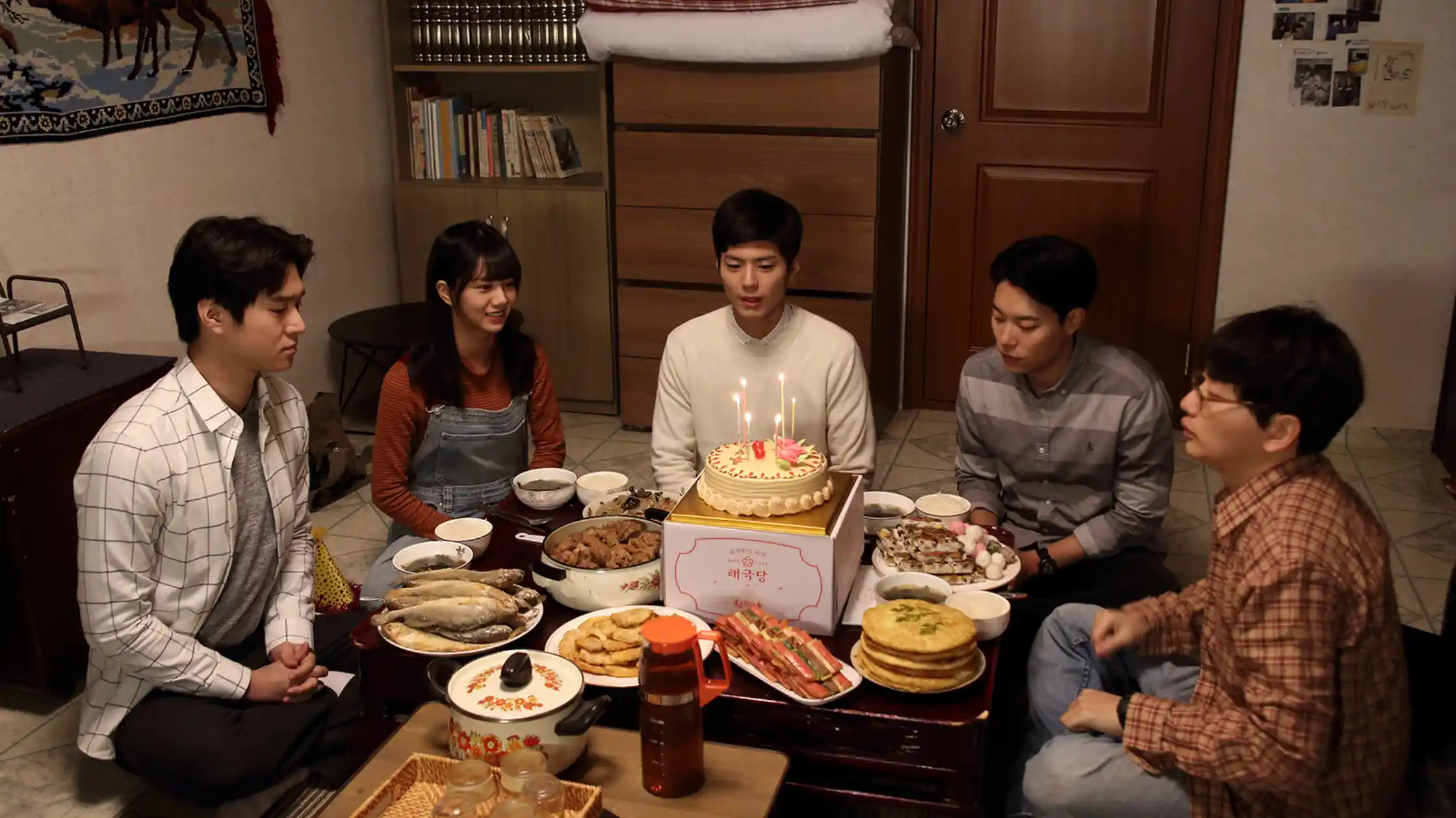 Imagem dos personagens ao redor de algumas comidas dos doramas